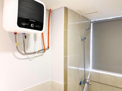 a bathroom with a shower with a television on the wall at Best Deal and Cozy 3BR Meikarta Apartment By Travelio in Cikarang
