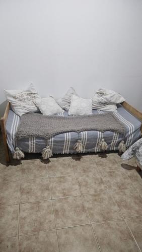 - un lit dans une chambre revêtue de carrelage dans l'établissement Residencia villa monica, à Capilla del Monte