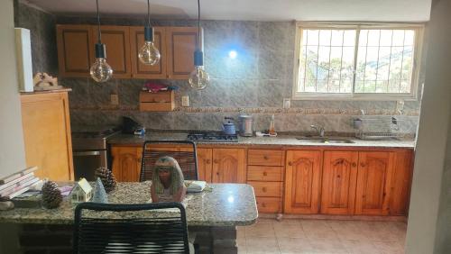 une cuisine avec des armoires en bois et un comptoir avec une table dans l'établissement Residencia villa monica, à Capilla del Monte