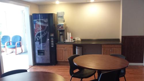 a room with two tables and a soda machine at McMurray Inn in Fort McMurray