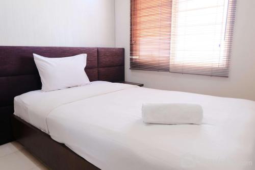a white bed with a white pillow on top of it at Spacious 3BR Combined Unit at Pinewood Apartment By Travelio in Sumedang