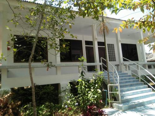 a white house with stairs in front of it at LayTrang Pakmeng Marina Spa and Resort in Trang