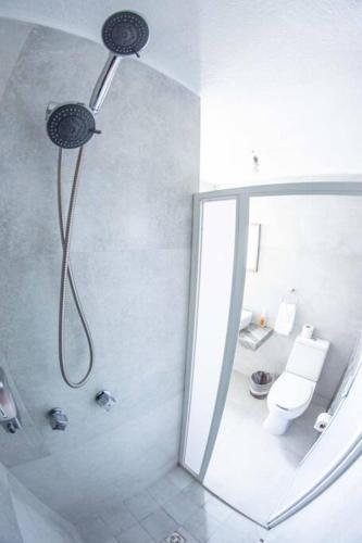 a bathroom with a shower with a toilet and a mirror at Estadía - buenaventura- Morelia Mich Coto privado in Morelia