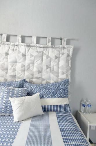 a bedroom with a bed with blue and white pillows at Estadía - buenaventura- Morelia Mich Coto privado in Morelia
