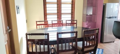a kitchen with a table with chairs and a refrigerator at Texas Heritage Guest house 4 Bedrooms in Trivandrum