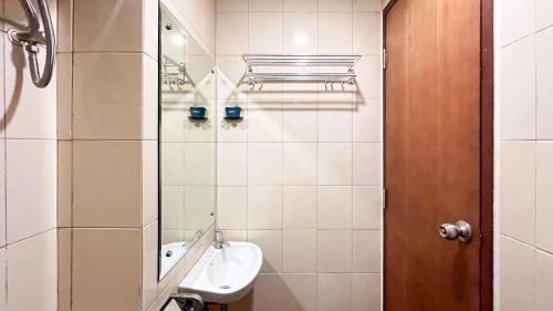 a small bathroom with a sink and a mirror at Simply and Cozy Living Studio Vida View Makassar Apartment By Travelio in Pampang