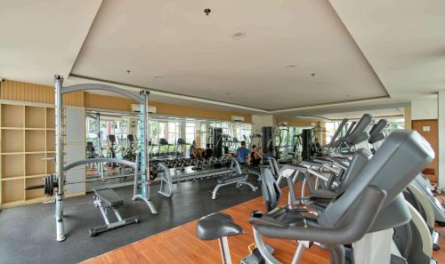 a gym with a bunch of tread machines in it at Compact 2BR at Apartemen Vida View Makassar by Travelio in Pampang
