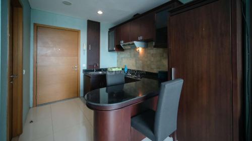a kitchen with a black counter top in a room at Homey 1BR Apartment at Aryaduta Residence Surabaya By Travelio in Surabaya