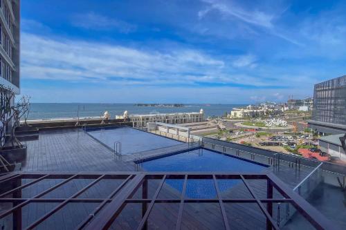a view of the ocean from a balcony of a building at Best Deal Studio Room at Delft Ciputra Makassar Apartment By Travelio in Sungguminasa