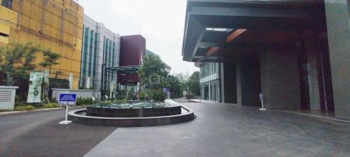 a building with a fountain in the middle of a street at Simple and Clean 2BR at Grand Sungkono Lagoon Apartment By Travelio in Surabaya