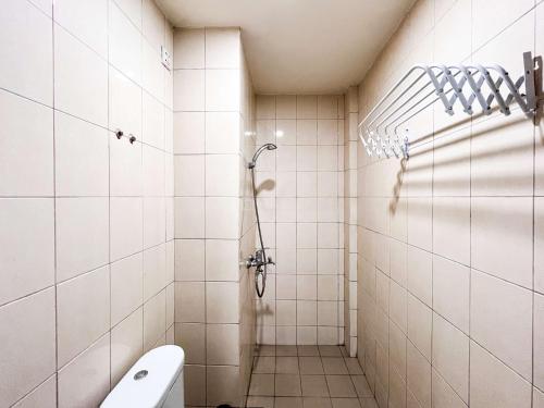 a bathroom with a shower and a toilet at Spacious Studio Room at Vida View Makassar Apartment By Travelio in Pampang