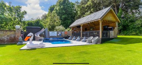 un patio trasero con piscina y cenador en Luxury retreat 32c pool jacuzzi games bar oasis, en Deal