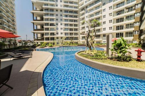 a large swimming pool in the middle of a building at Spacious 3BR at Gateway Pasteur Apartment By Travelio in Bandung