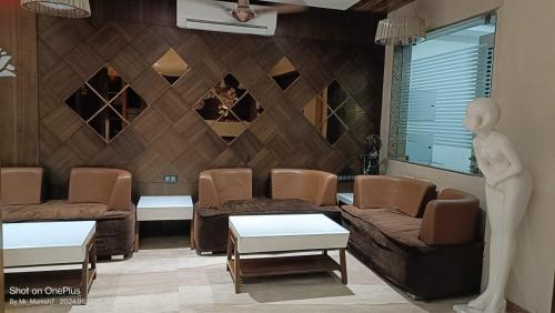 a living room with couches and a mannequin at Hotel Ranjeet Akola in Akola