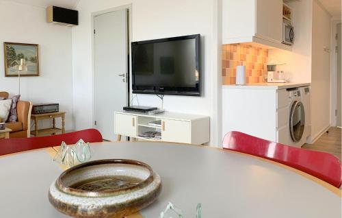 a living room with a table and a television at Apartment Skudehavnen in Rudkøbing
