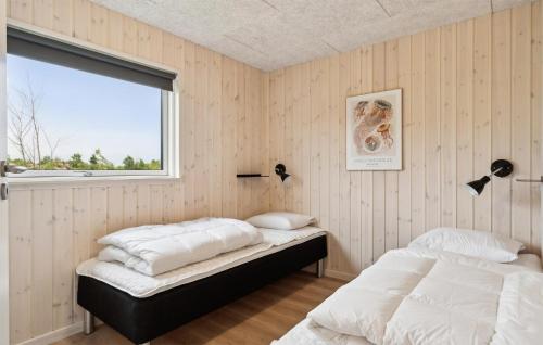 two beds in a room with a window at Stunning Home In Ålbæk With Sauna in Ålbæk