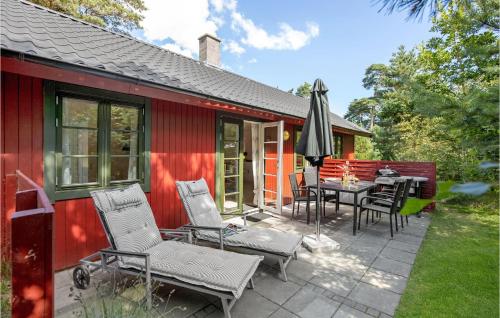 Neksøにある3 Bedroom Cozy Home In Nexøのパティオに椅子と傘が置かれた赤い家