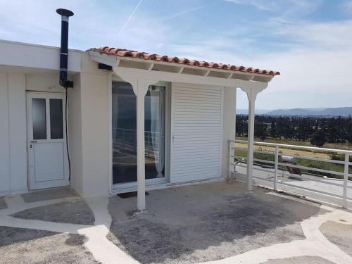 a white house with a porch with a roof at Cute&Quiet Studio Loutraki in Loutraki