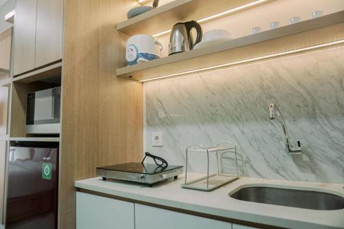 a kitchen with a sink and a counter top at Modern Studio at Pacific Garden - Campus Town @Alam Sutera Apartment By Travelio in Tangerang