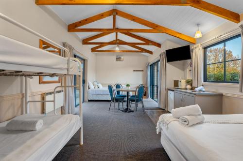 a bedroom with two bunk beds and a table at Tasman Holiday Parks - Te Anau in Te Anau