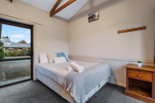 a bedroom with a bed and a window at Tasman Holiday Parks - Te Anau in Te Anau