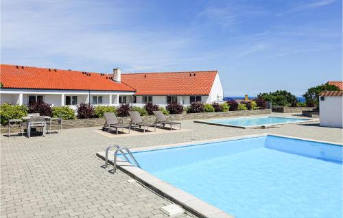 a swimming pool in front of a house at 1 Bedroom Nice Apartment In Gudhjem in Gudhjem