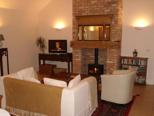 a living room with a couch and a fireplace at The Hall Farm Bed And Breakfast in Tilbrook
