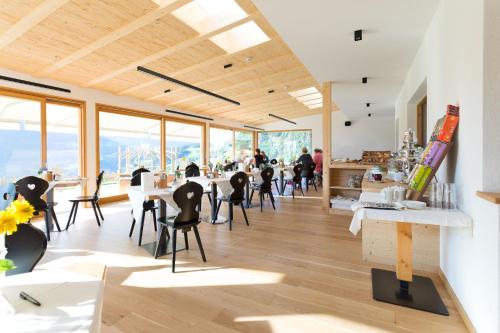 a room with tables and chairs and windows at Hotel-Chalet Pennhof in Barbiano