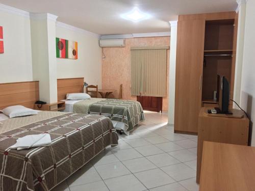 um quarto de hotel com duas camas e uma televisão de ecrã plano em Magnus Plaza Hotel em Macapá