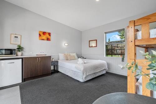 a white bedroom with a bed and a window at Tasman Holiday Parks - Te Anau in Te Anau