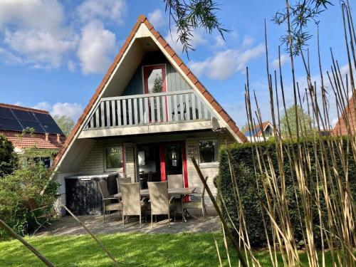 a house with a table and chairs in the yard at Ferienhaus in Anjum mit Kleinem Balkon in Anjum