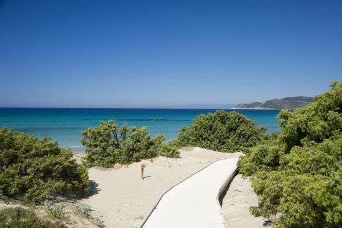 a path to the beach with the ocean in the background at Hotel Fiore Di Maggio in Villasimius