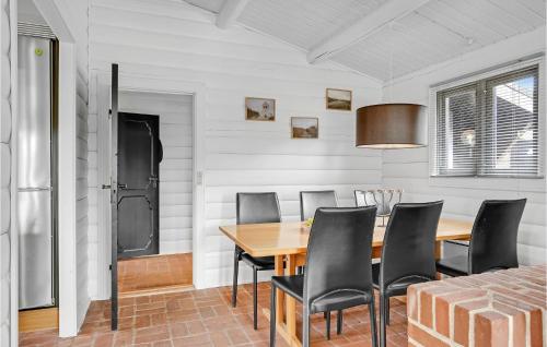 a dining room with a wooden table and black chairs at Holiday Home Ålykke Juelsminde I Denmark in Sønderby