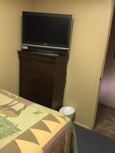 a bedroom with a television on a dresser with a bed at Harrison Inn in Duchesne