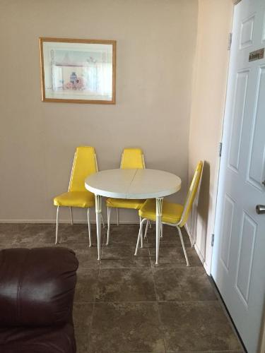 a table and two yellow chairs in a room at Harrison Inn in Duchesne