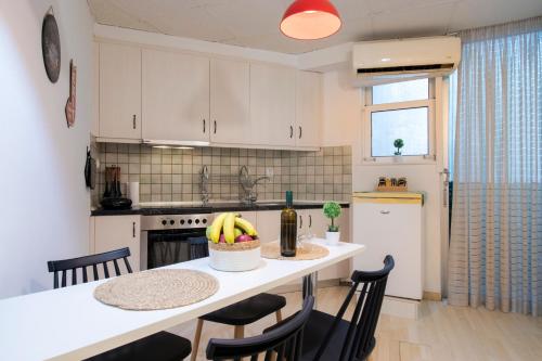 a kitchen with a table with a bowl of bananas on it at Modern City Apt in the Heart of Heraklion in Heraklio Town