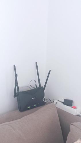 a black router sitting on top of a bed at Bel Appart Marina Golf Asilah in Asilah