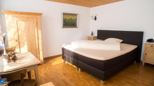 a bedroom with a bed and a table and a window at Hotel Badhof in Altstätten