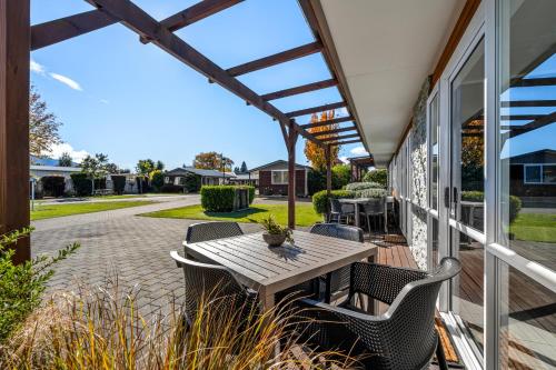 a patio with a table and chairs on a house at Tasman Holiday Parks - Te Anau in Te Anau