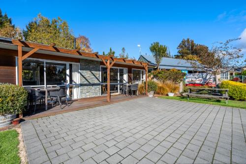 an outdoor patio with a table and chairs at Tasman Holiday Parks - Te Anau in Te Anau