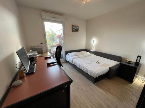 une chambre avec un lit et un bureau avec un ordinateur dans l'établissement Duplex Terrasse au soleil, à Paris