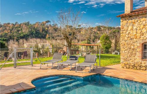 a patio with two chairs and a swimming pool at 4 Bedroom Nice Home In Riells I Viabrea in Breda