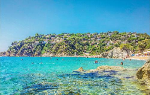 a group of people in the water at a beach at 4 Bedroom Nice Home In Riells I Viabrea in Breda