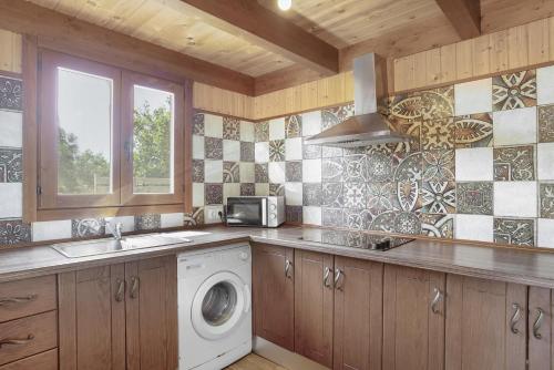 - une cuisine équipée d'un lave-linge, d'un évier et d'une cuisinière dans l'établissement Casa el mirlo, à Conil de la Frontera