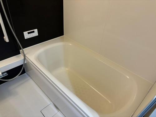 a white bath tub in a small bathroom at Base605 in Kurume
