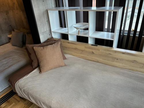 a bed sitting in a room with a window at Base605 in Kurume
