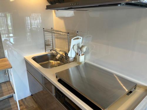 a kitchen with a stainless steel sink and a counter at Base605 in Kurume