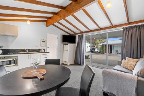 a kitchen and living room with a table and chairs at Tasman Holiday Parks - Te Anau in Te Anau