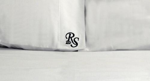 a close up of the corner of a bed with white sheets at Ribera Sur Hotel Mar del Plata in Mar del Plata
