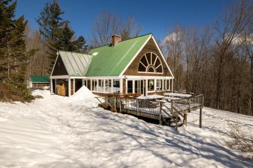 a house with a green roof in the snow at Sunburst in Killington